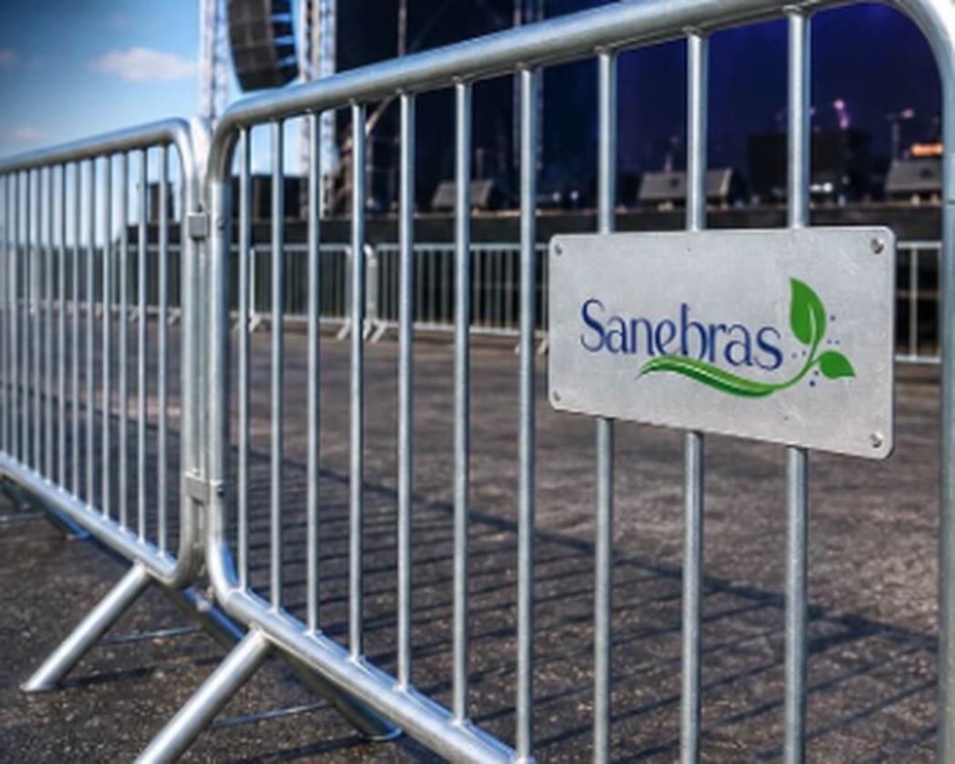 Grades metálicas de fechamento da Sanebras instaladas em evento, com placa da marca Sanebras